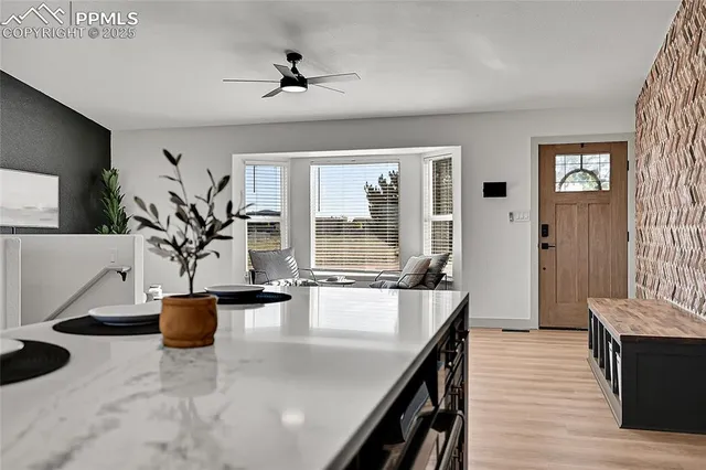 a dining hall with couches a flat tv screen and a dining table with wooden floor