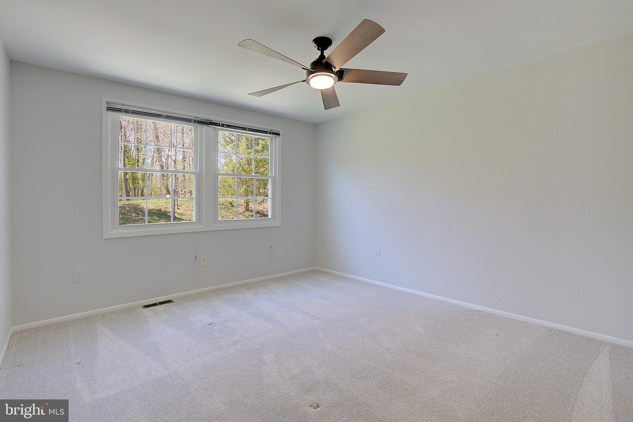 12702 Cedarbrook Lane Laurel, MD 20708 - Photo 24 of 43 an empty room with chandelier fan and windows