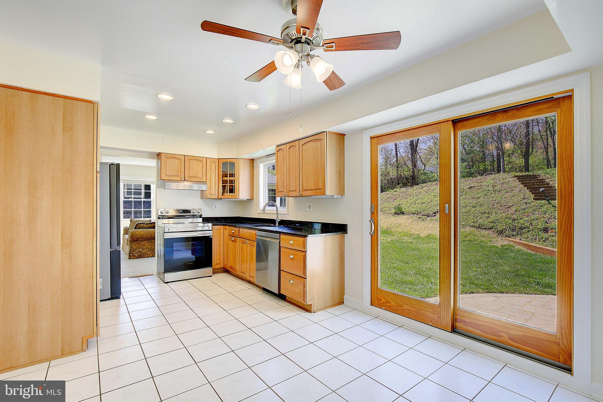 12702 Cedarbrook Lane Laurel, MD 20708 - Photo 10 of 43 a large kitchen with stainless steel appliances granite countertop a refrigerator a oven and a sink with granite countertops