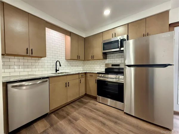 a kitchen with stainless steel appliances a refrigerator sink and microwave