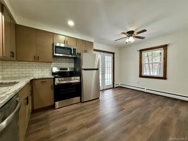 a kitchen with granite countertop a refrigerator stove top oven and sink
