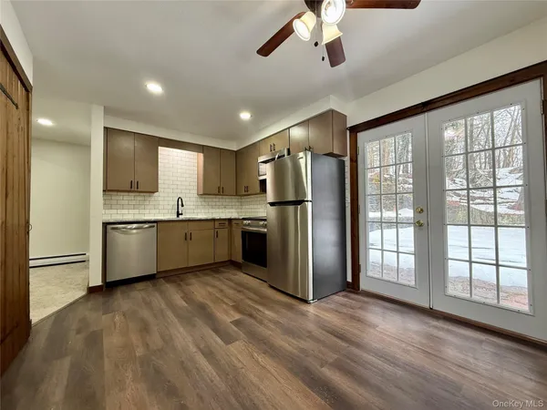 a large kitchen with a large window stainless steel appliances and cabinets