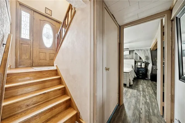 a view of a hallway with wooden floor and a front door