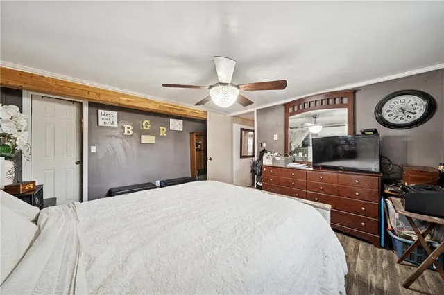 a bedroom with a large bed and a ceiling fan