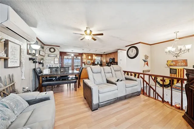 a living room with furniture kitchen view and a window