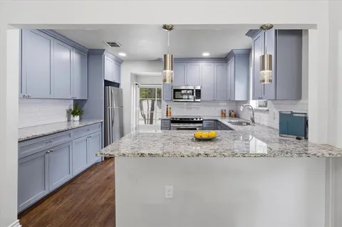 a kitchen with sink refrigerator and cabinets