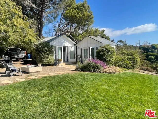 a front view of a house with sitting area and garden
