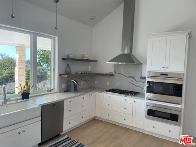a kitchen with granite countertop white cabinets and white stainless steel appliances