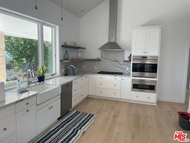 a kitchen with granite countertop white cabinets and white appliances
