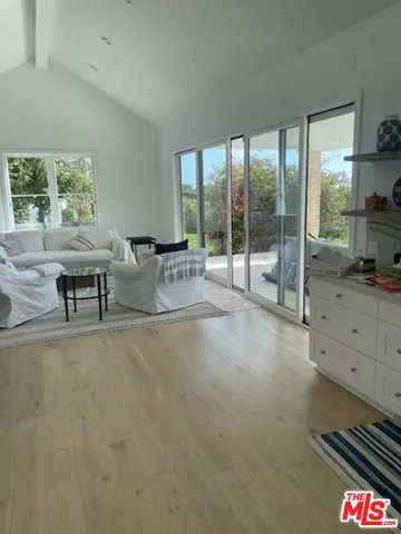 a living room with furniture and a floor to ceiling window