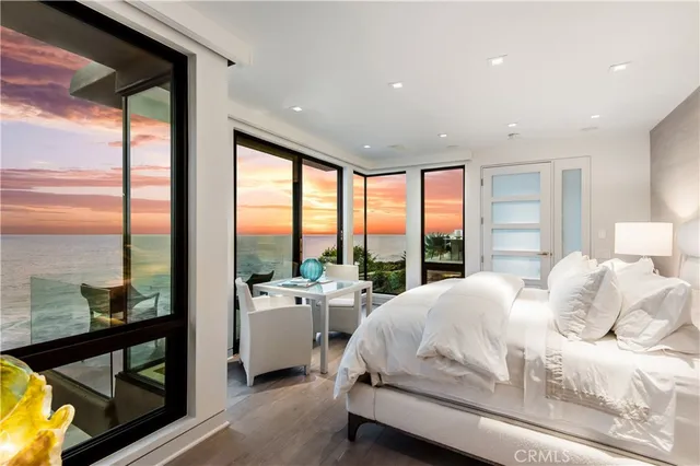 a room with a bed and large windows