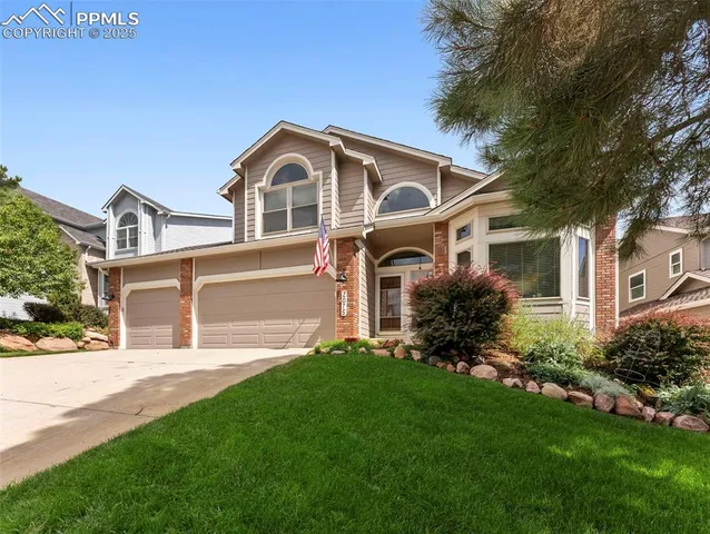 a front view of a house with a yard and trees