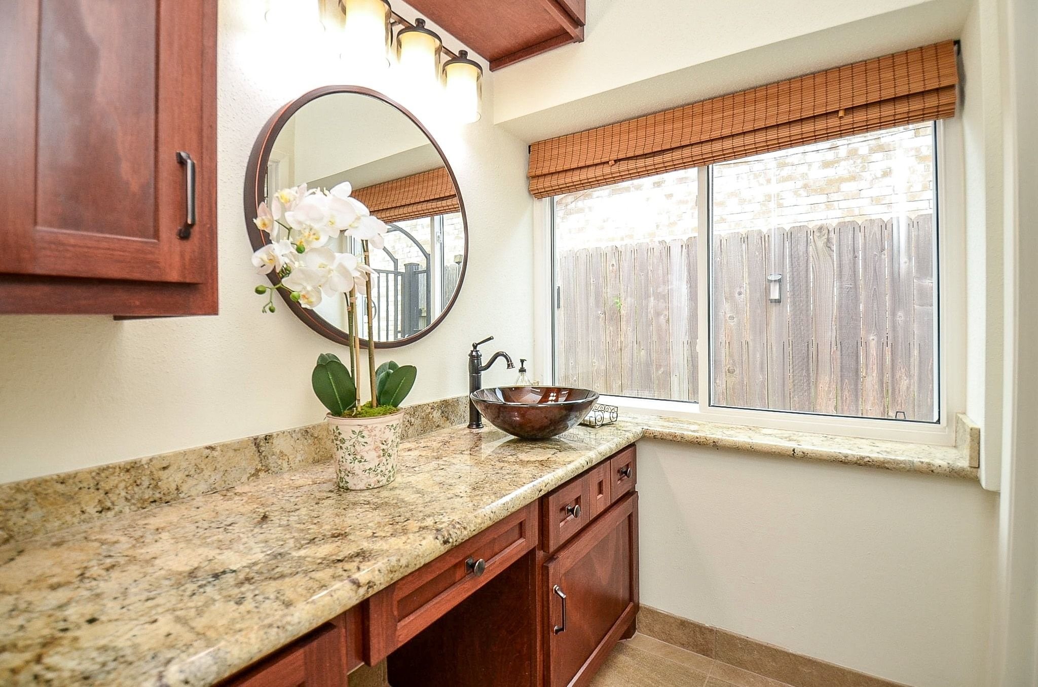 22810 John Rolfe Lane Katy, TX 77449 - Photo 12 of 20 a bathroom with a granite countertop sink and a mirror