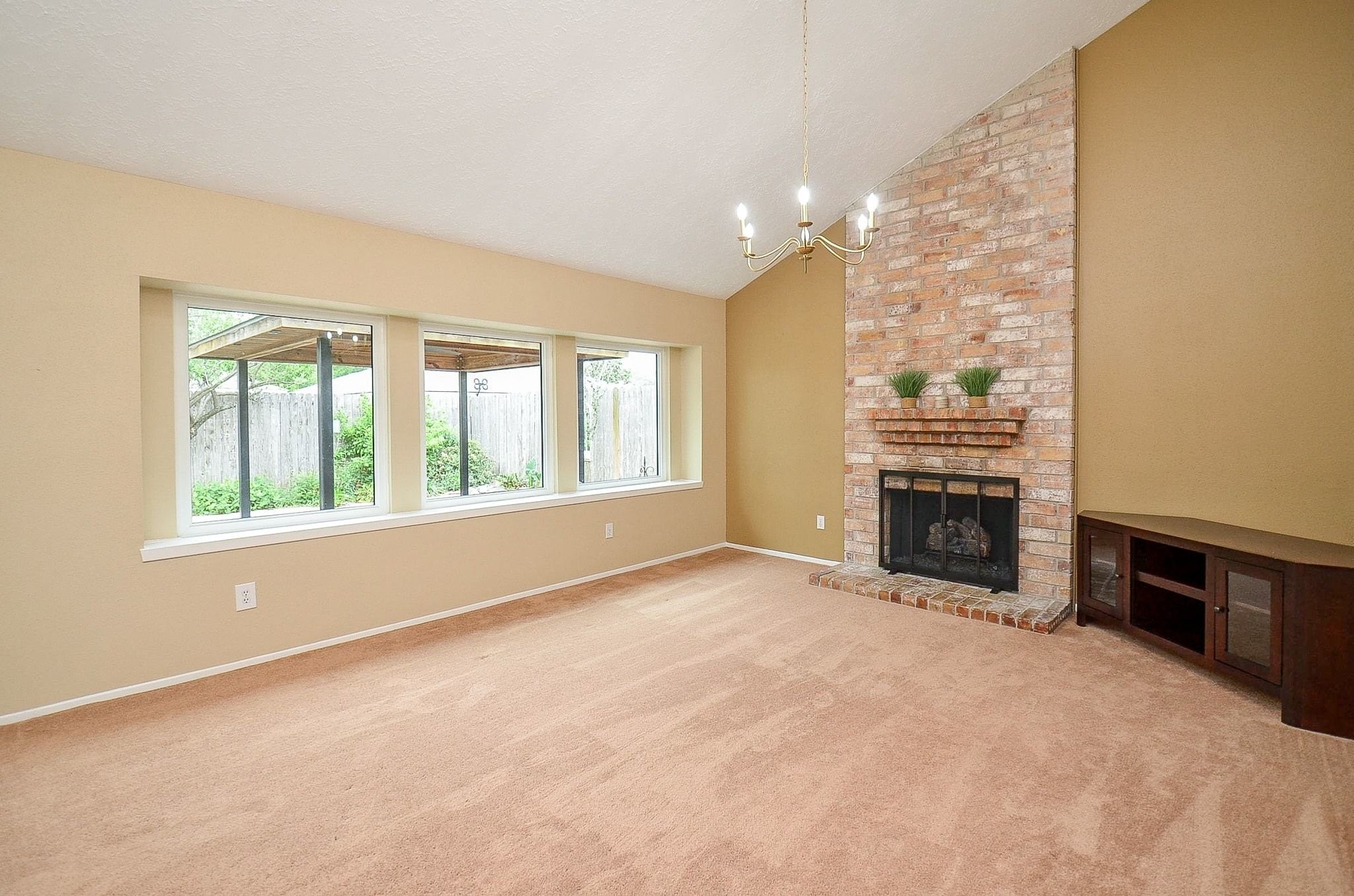 22810 John Rolfe Lane Katy, TX 77449 - Photo 6 of 20 an empty room with windows fireplace and fans