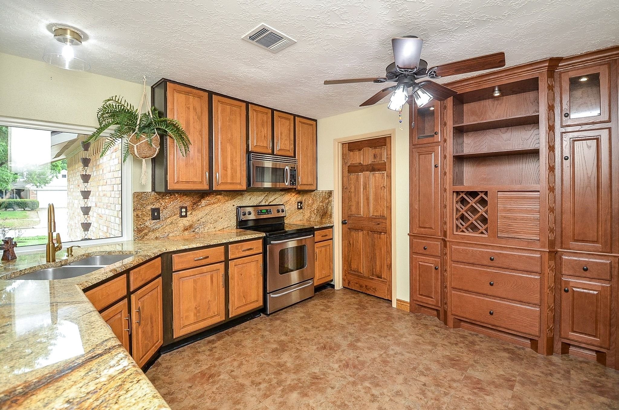 22810 John Rolfe Lane Katy, TX 77449 - Photo 8 of 20 a kitchen with stainless steel appliances kitchen island granite countertop a refrigerator and a stove top oven