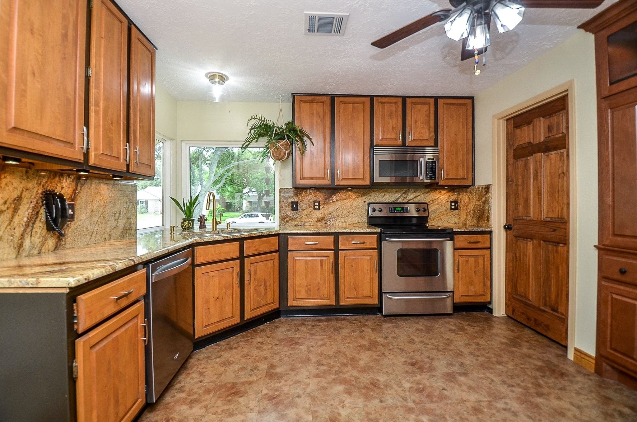 22810 John Rolfe Lane Katy, TX 77449 - Photo 9 of 20 a kitchen with granite countertop a stove a sink and a refrigerator