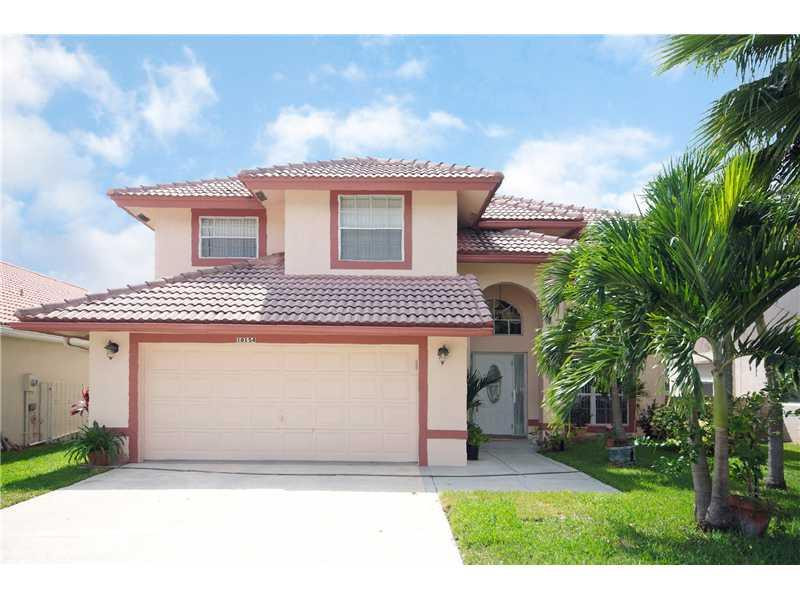 10154 Aqua Vista Way Boca Raton, FL 33428 - Photo 1 of 22 a front view of a house with a garden and tree