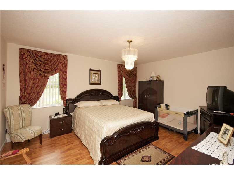 10154 Aqua Vista Way Boca Raton, FL 33428 - Photo 16 of 22 a bedroom with a bed and wooden floor