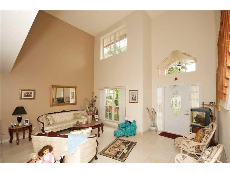 10154 Aqua Vista Way Boca Raton, FL 33428 - Photo 2 of 22 a living room with furniture a rug and a chandelier