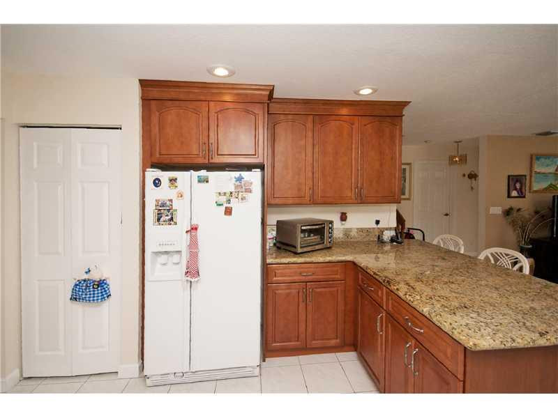 10154 Aqua Vista Way Boca Raton, FL 33428 - Photo 6 of 22 a kitchen with granite countertop a refrigerator a sink a stove and wooden cabinets