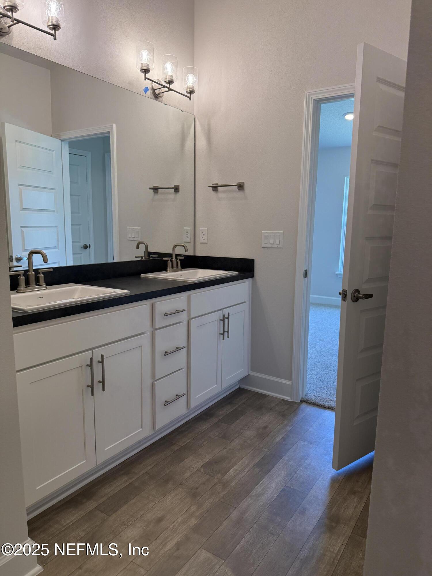 8340 Helmsley Boulevard Jacksonville, FL 32219 - Photo 12 of 56 a spacious bathroom with a granite countertop sink and a mirror