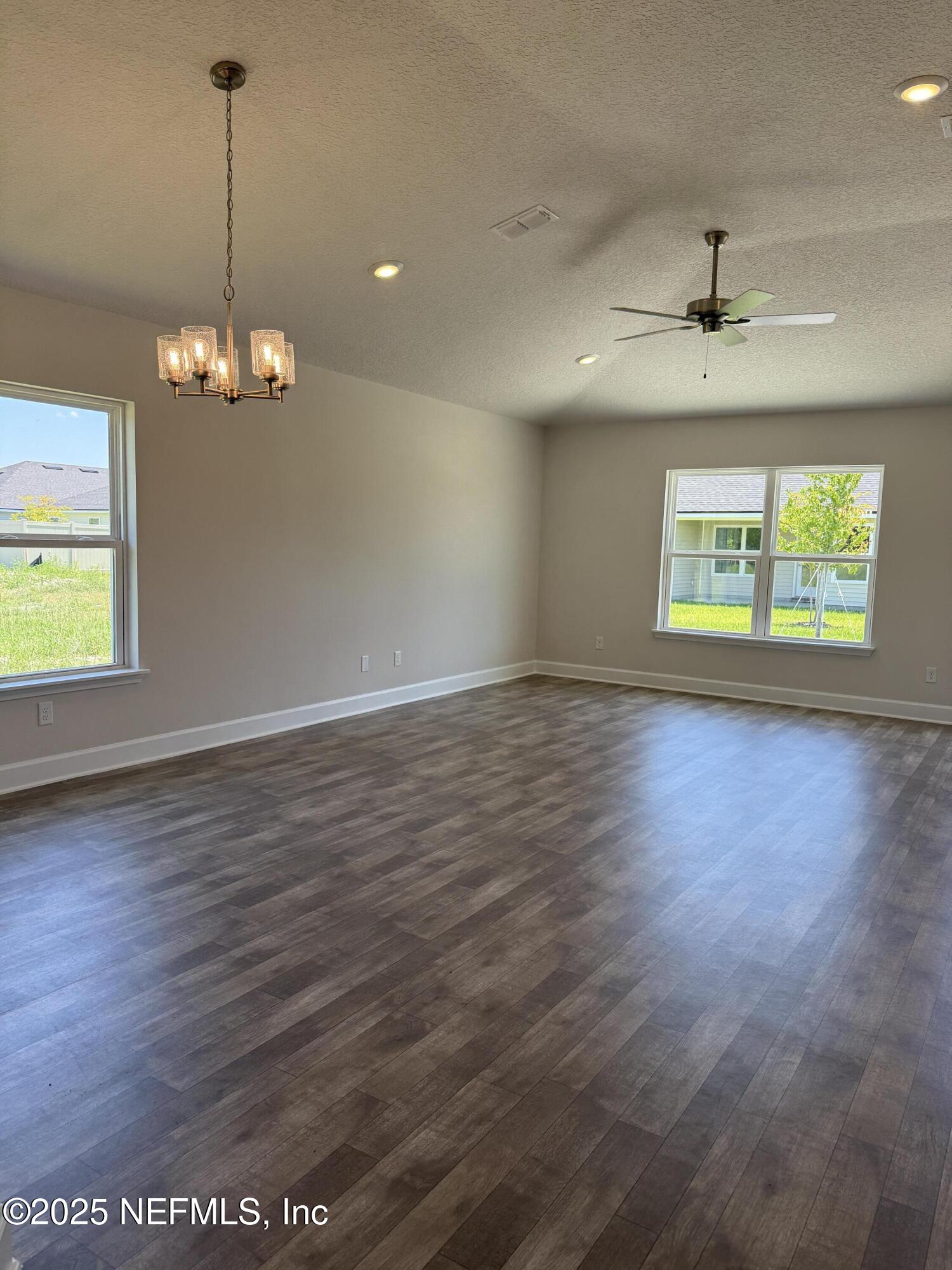 8340 Helmsley Boulevard Jacksonville, FL 32219 - Photo 4 of 56 an empty room with wooden floor chandelier and windows