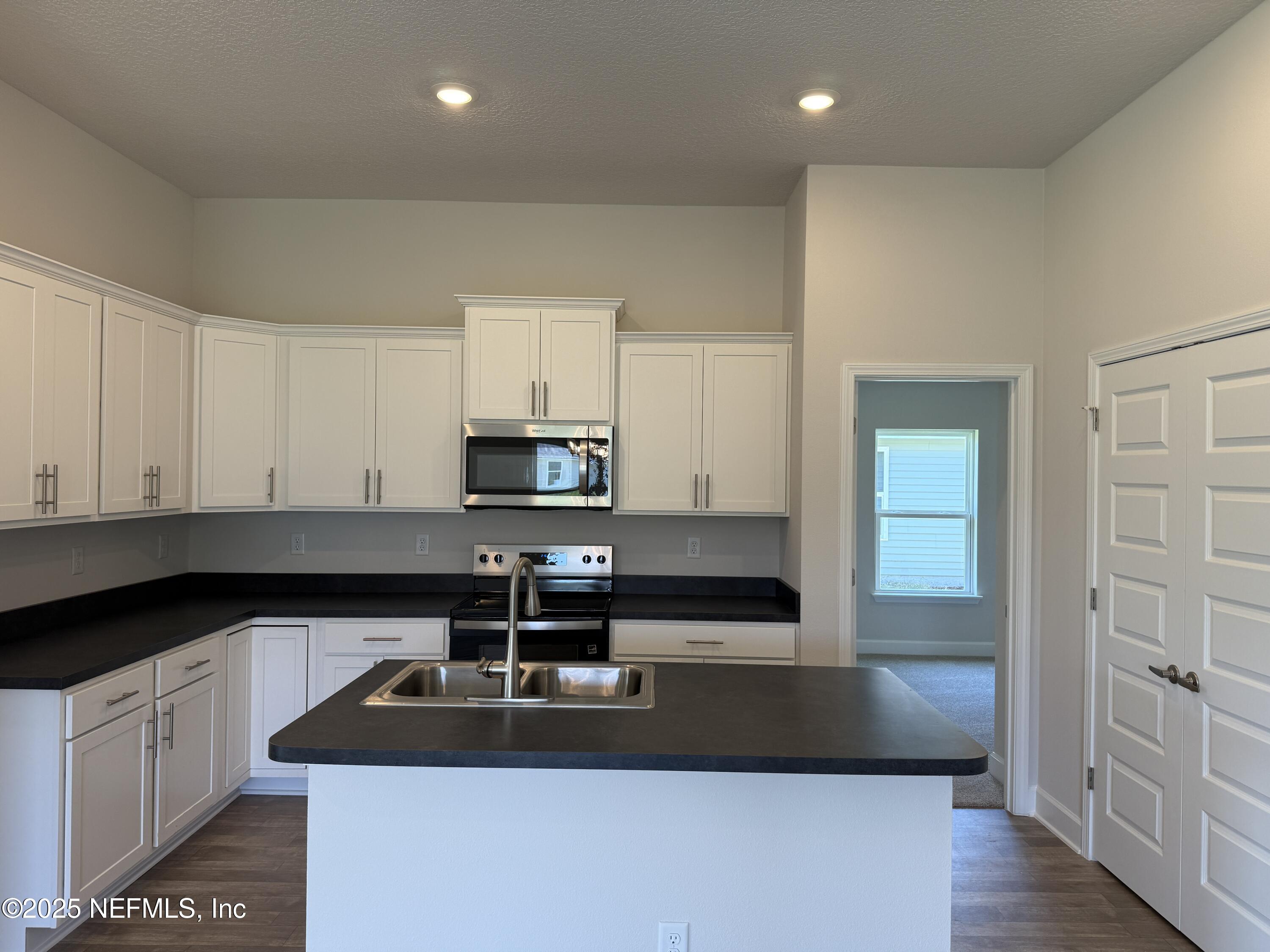 8340 Helmsley Boulevard Jacksonville, FL 32219 - Photo 5 of 56 a kitchen with kitchen island granite countertop a sink a stove and cabinets