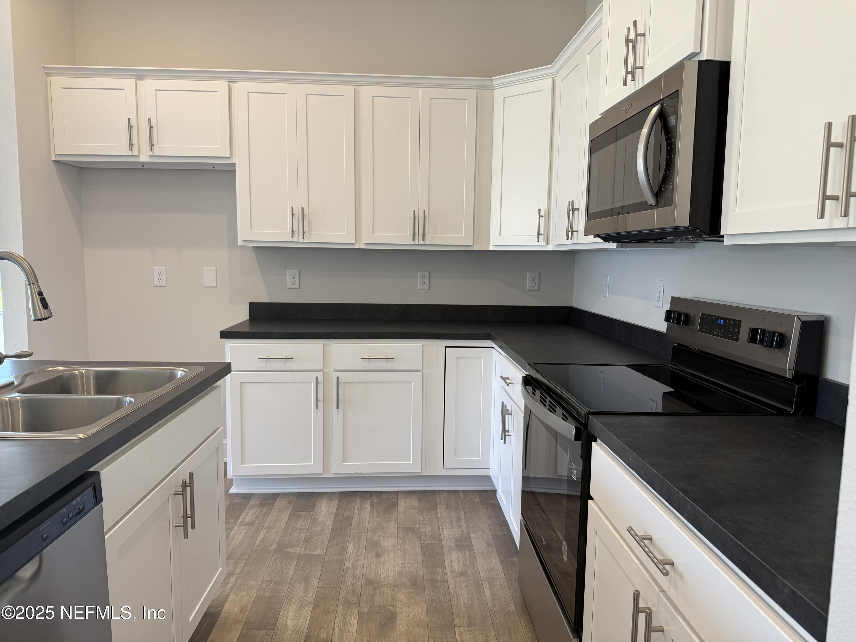 8340 Helmsley Boulevard Jacksonville, FL 32219 - Photo 7 of 56 a kitchen with granite countertop a sink dishwasher stove and cabinets