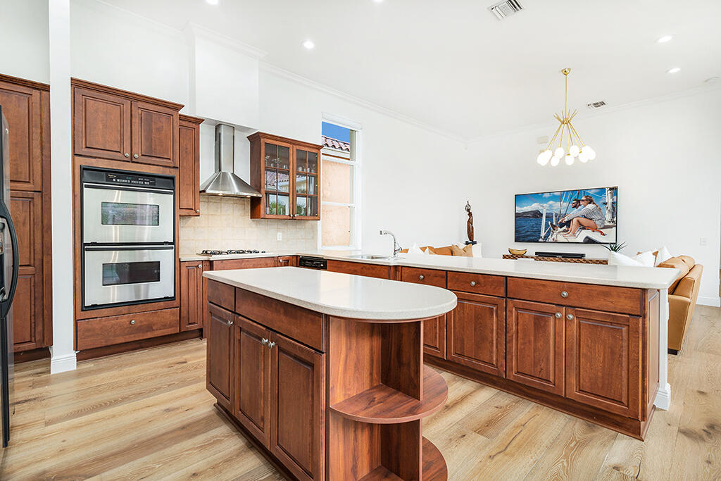 317 Galicia Way Jupiter, FL 33458 - Photo 20 of 31 a kitchen with stainless steel appliances granite countertop a sink and wooden cabinets