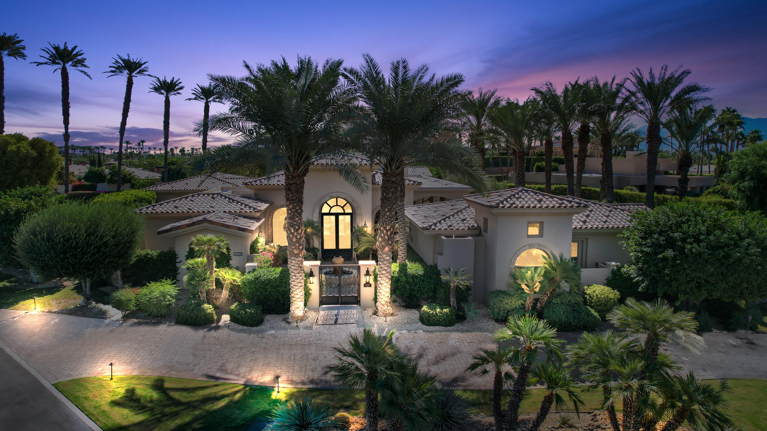 a view of a house with a yard and potted plants