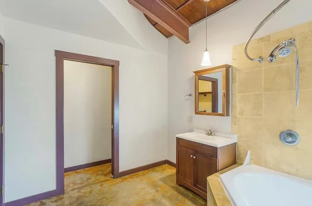 a bathroom with a tub sink and mirror