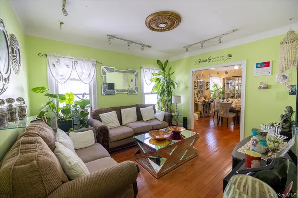 a living room with furniture kitchen view and a large window