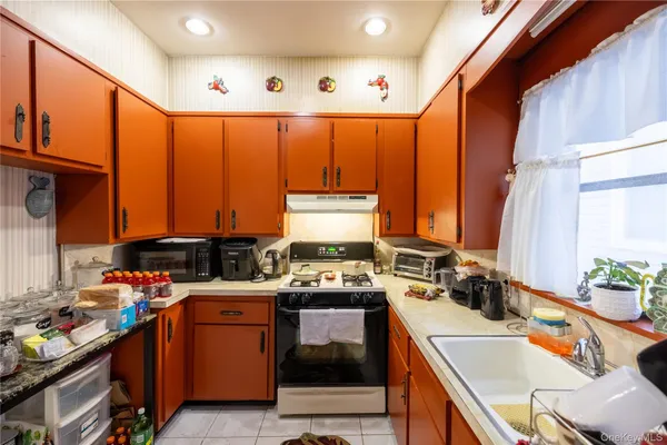 a kitchen with stainless steel appliances a sink window and cabinets