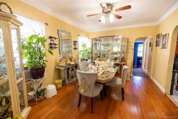 a dining room with furniture potted plants and wooden floor