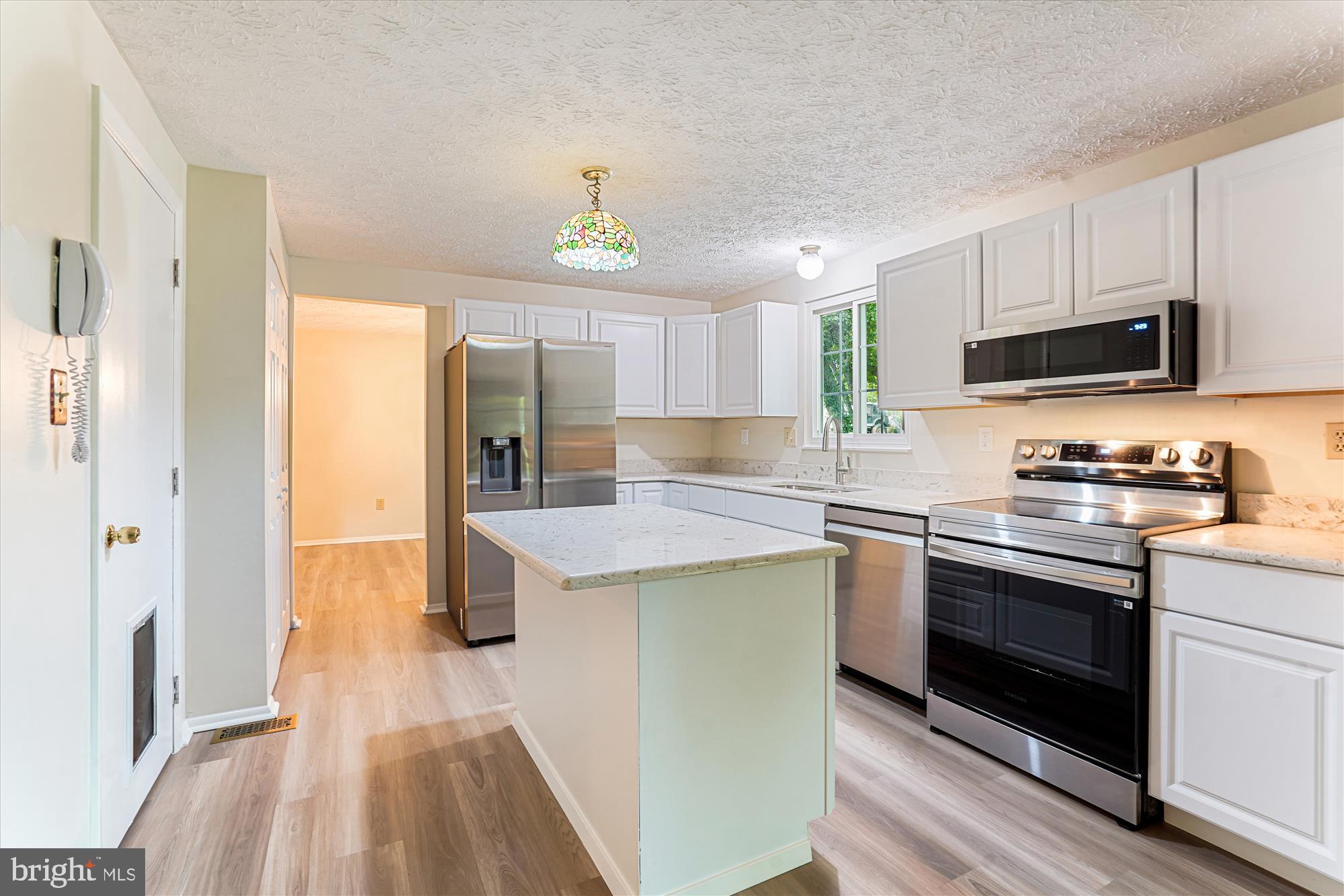 1221 Windmill Lane Silver Spring, MD 20905 - Photo 12 of 38 a kitchen with kitchen island granite countertop a sink cabinets and stainless steel appliances