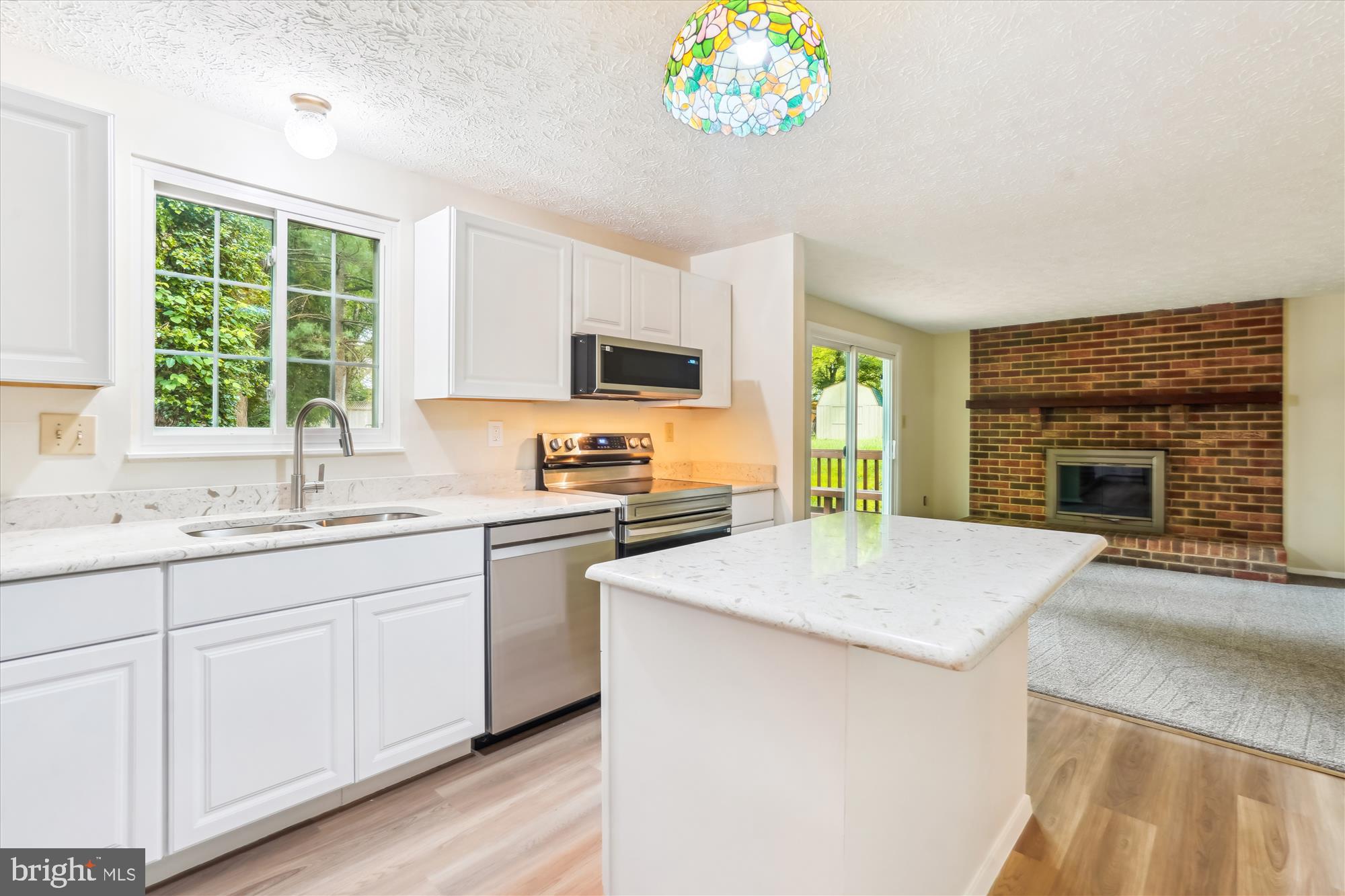 1221 Windmill Lane Silver Spring, MD 20905 - Photo 10 of 38 a kitchen with kitchen island a sink stove and microwave