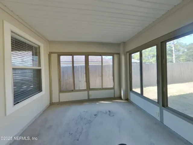 a view of an empty room with large windows