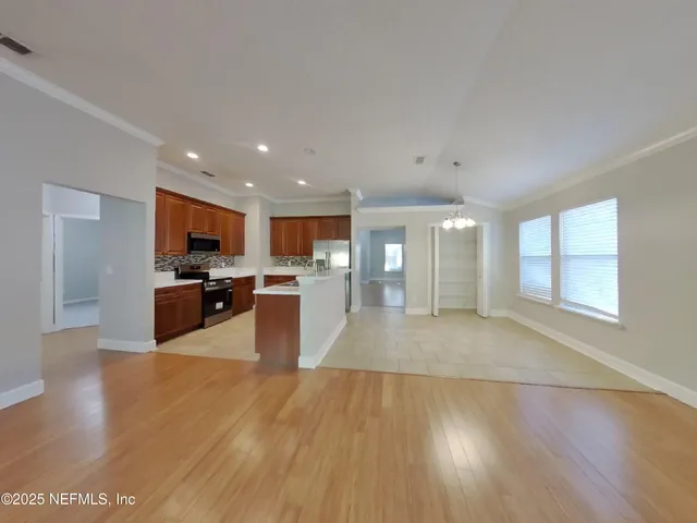 a large kitchen with cabinets wooden floor and stainless steel appliances