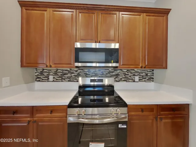a stove top oven sitting inside of a kitchen