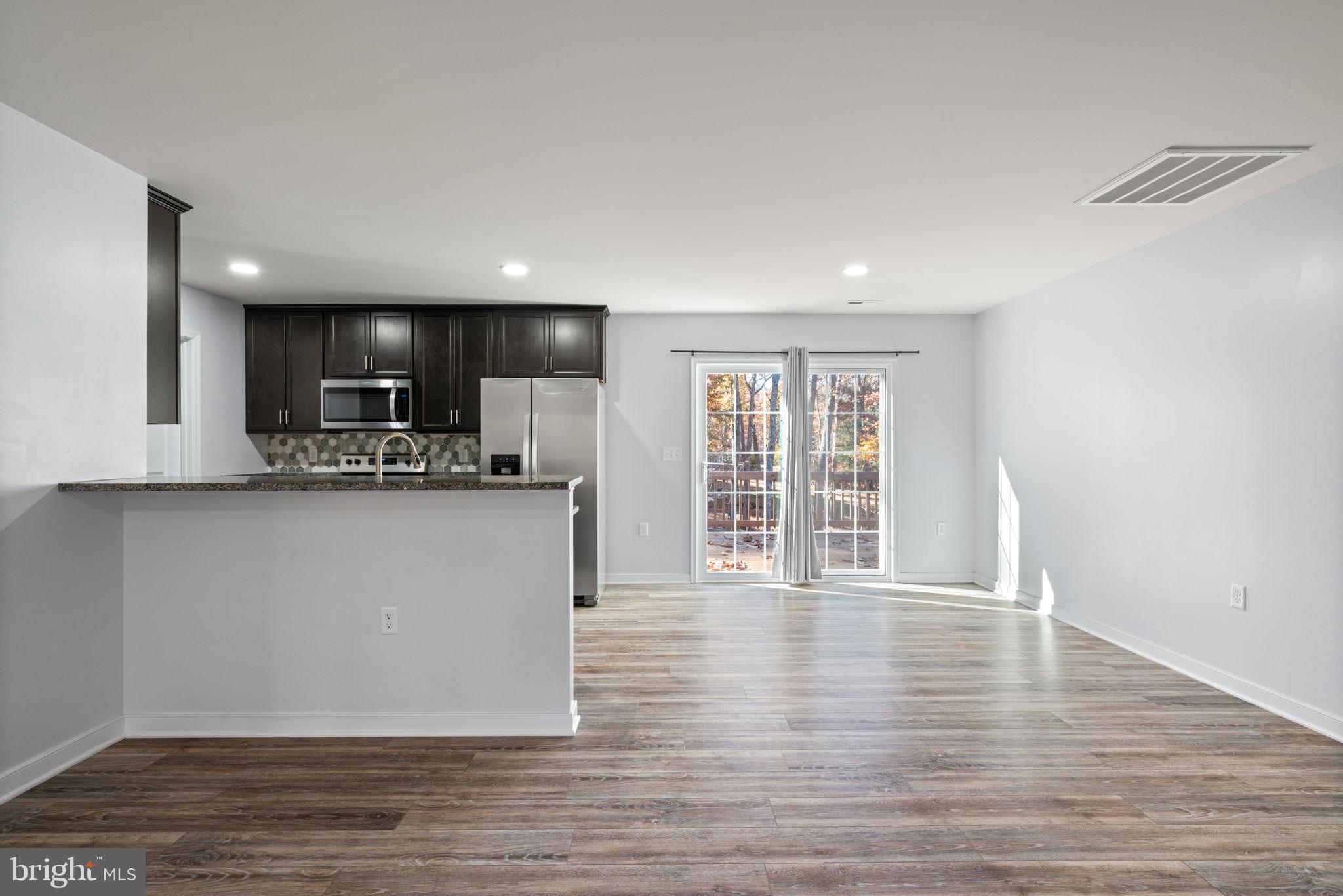 55 Cedar Circle Mineral, VA 23117 - Photo 15 of 44 a view of kitchen with stainless steel appliances granite countertop a refrigerator a stove top oven and a wooden floors