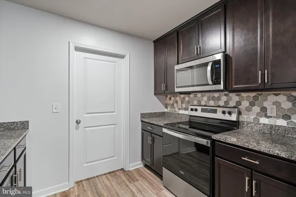 a kitchen with kitchen island granite countertop a sink stove and refrigerator