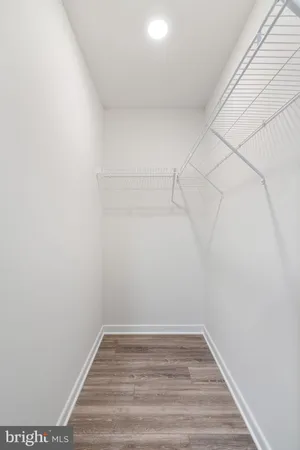 an empty room with wooden floor ceiling fan and windows