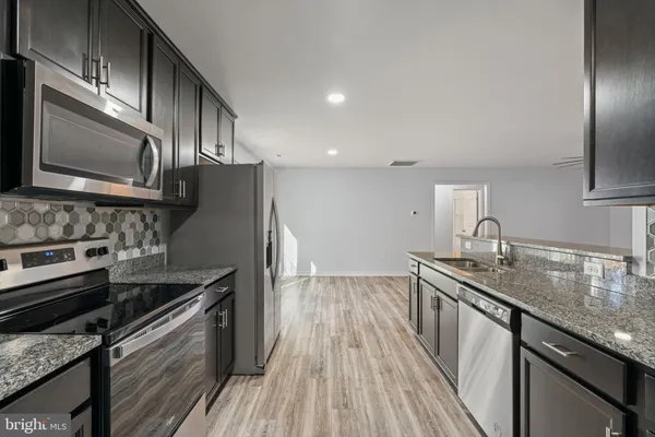 a living room with furniture a dining table and chairs with wooden floor