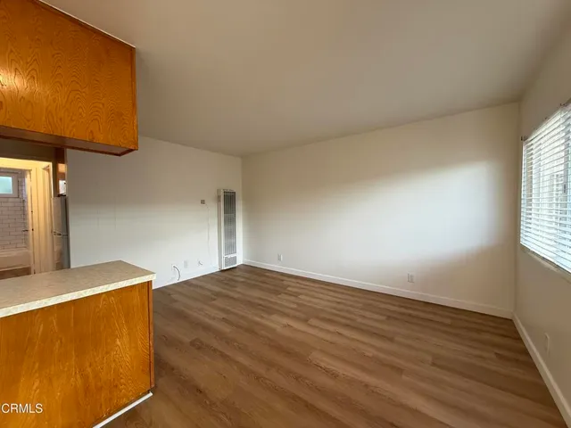 a view of empty room with wooden floor
