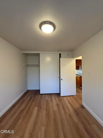 an empty room with wooden floor and closet