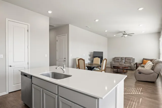 a kitchen with stainless steel appliances a sink a stove a chimney a refrigerator and cabinets