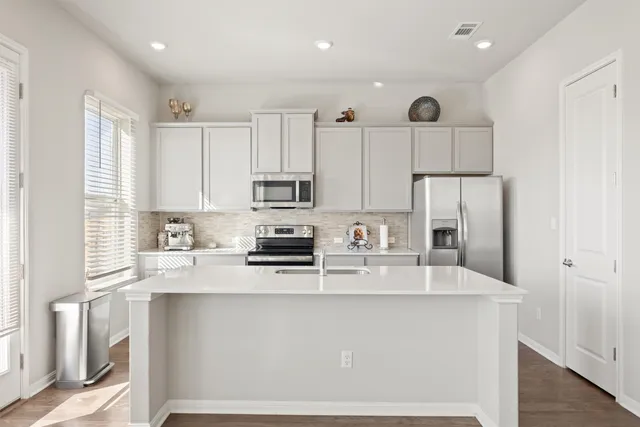 a kitchen with stainless steel appliances granite countertop a refrigerator sink stove and microwave