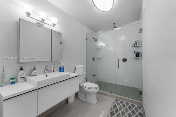 a bathroom with a double vanity sink toilet mirror and shower
