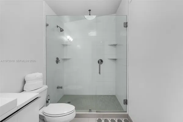 a bathroom with a granite countertop shower a toilet and a sink