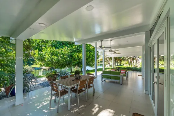 a dining room with furniture and a floor to ceiling window